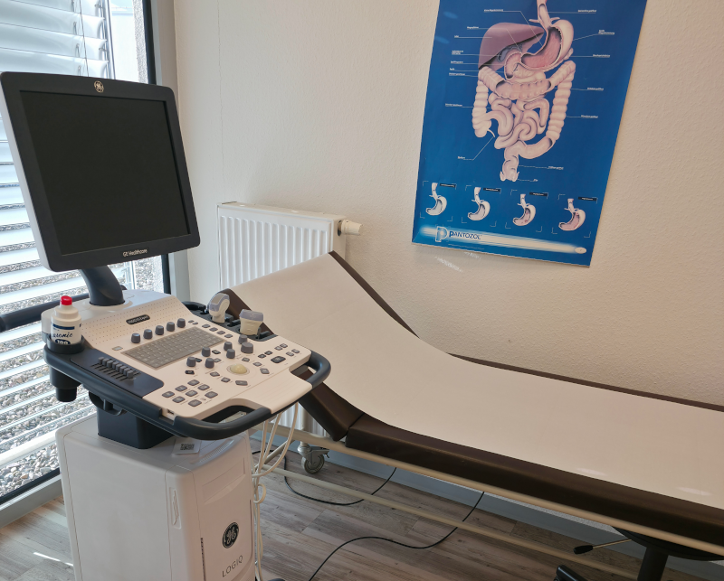 Dieses Bild zeigt ein Ultraschallgerät und eine Liege.